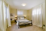 The in-law suite bedroom features a queen size bed and acts as a second master. 